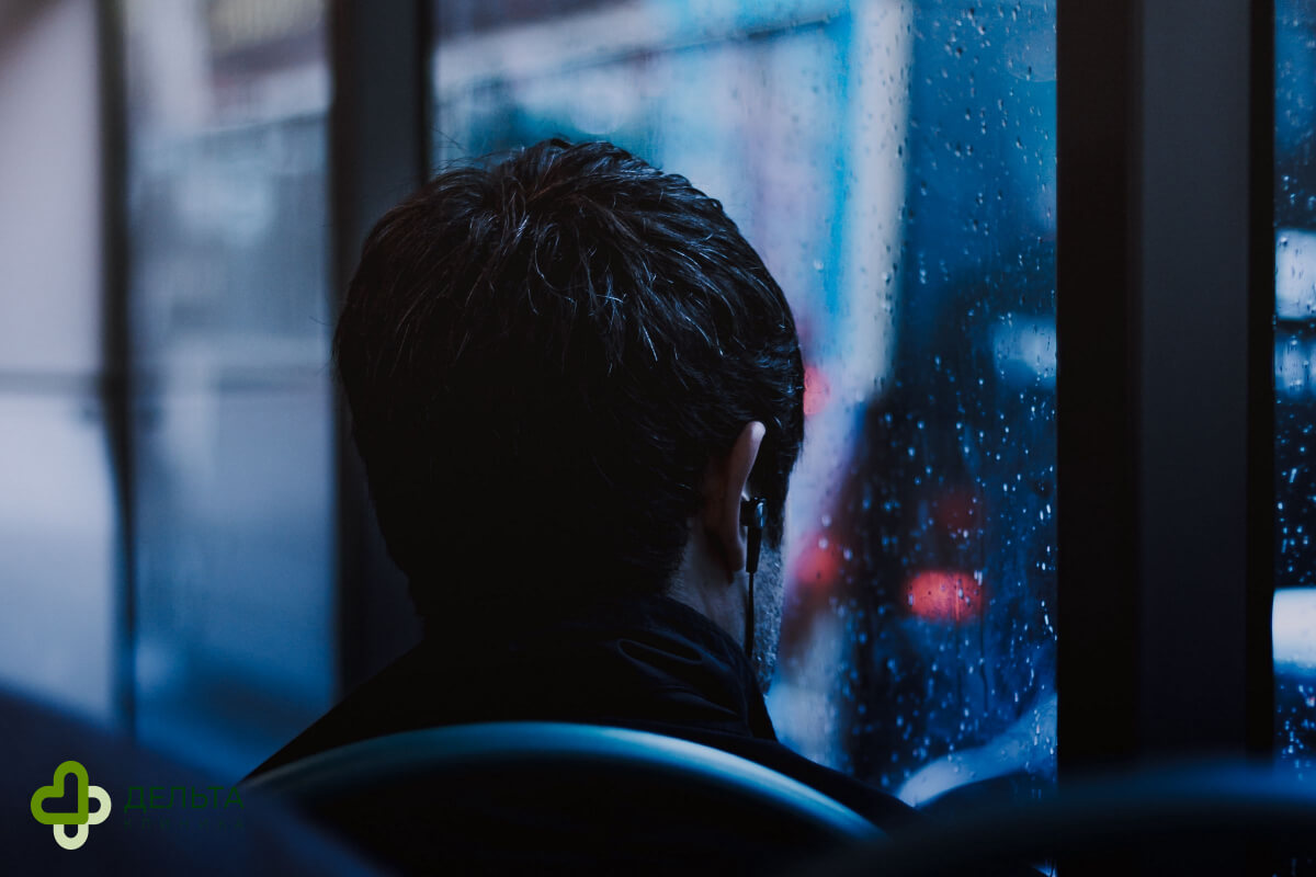 Мужчина смотрит в окно